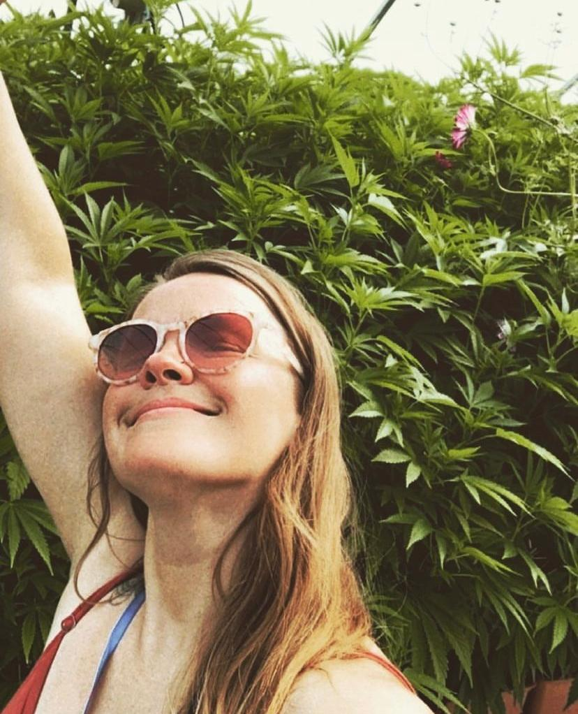 tiffani renee girl with sunglasses in front of a blooming cannabis plant