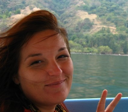 Cat Winske Content Writer Headshot of a woman on a boat with mountains in the background